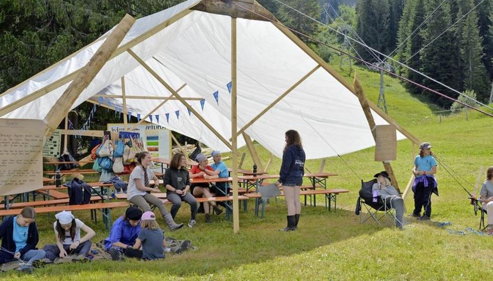 Einige Mädchen knüpfen Armbänder, während andere im «Gefängnis» darauf warten, von ihren Mitspielerinnen befreit zu werden. Bild Corina Mühle