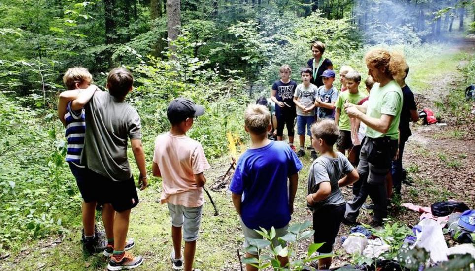 Gespannt lauschen die Kinder den Anweisungen und Erklärungen von Kursleiter Stephan Kelz. Weil sie es alle geschafft haben, ein Feuer zu machen, geht das Kursprogramm weiter. Bild: Maximilian Wiggenhauser