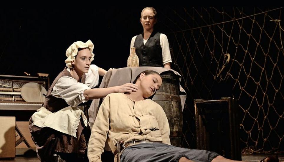Jim Hawkins (Mirella Weber) und seine Mutter (Fanny Nussbaumer) stellen entsetzt fest, dass der Steuermann (Agatha Kupper) durch einen Schlaganfall gestorben ist. Bild: Selwyn Hoffmann