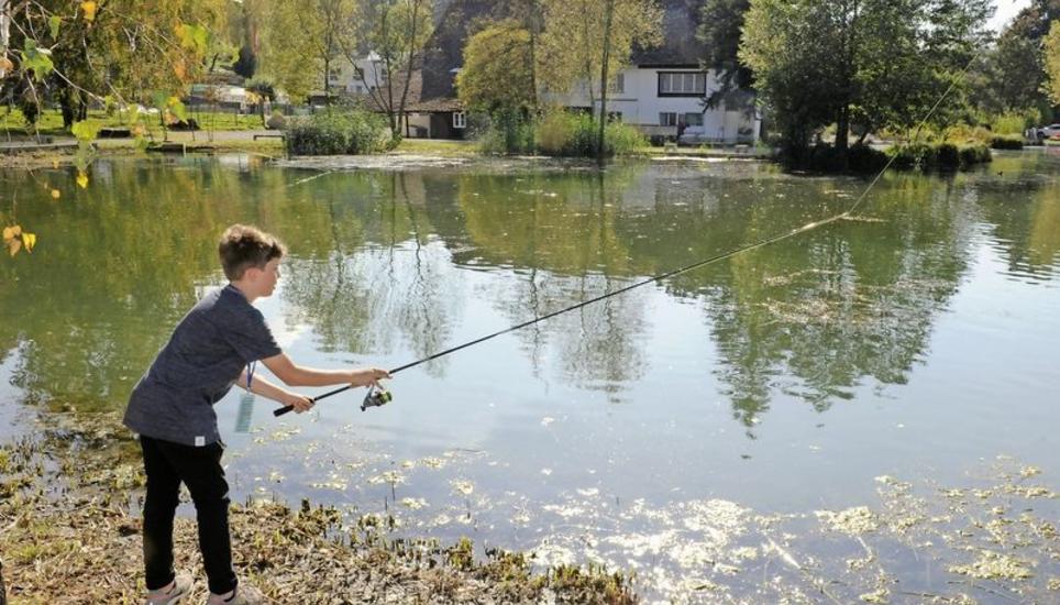 Schon fast ein Fischerprofi: Mit einem lockeren Wurf schickt der zwölfjährige Simon Signer den Köder über den Teich, in dem es hauptsächlich Forellen gibt. Im Hintergrund ist der Kundelfingerhof zu sehen. Bilder: Bruno + Eric Bührer