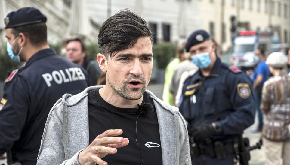 epa08382398 Martin Sellner, leader of the far right Identitarian Movement Austria (Identitaere Bewegung Oesterreich), speaks to journalists during a demonstration against the measures of the Austrian government to slow down the ongoing pandemic of the COV