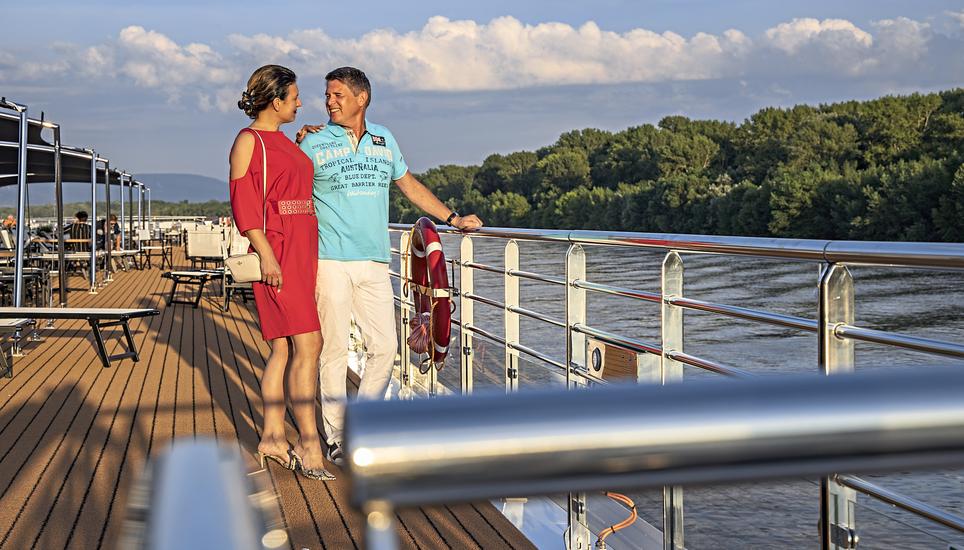Couple stands at railing on sun deck of river cruise ship Excellence Empress (ReisebÃ¼ro Mittelthurgau) on the Danube river, NyergesÃºjfalu, KomÃ¡rom-Esztergom, Hungary