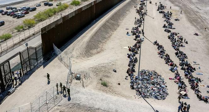FILE - Migrants form lines outside the border fence waiting for transportation to a U.S. Border Patrol facility in El Paso, Texas, May 10, 2023. A deal to provide further U.S. assistance to Ukraine by year-end appears to be increasingly out of reach for P