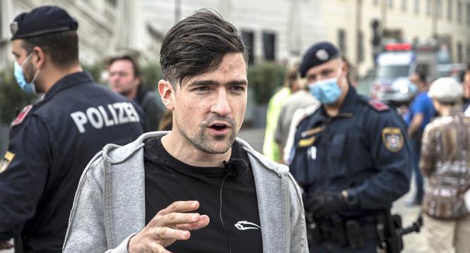 epa08382398 Martin Sellner, leader of the far right Identitarian Movement Austria (Identitaere Bewegung Oesterreich), speaks to journalists during a demonstration against the measures of the Austrian government to slow down the ongoing pandemic of the COV