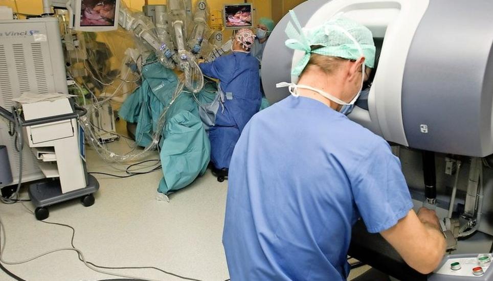 An der Konsole rechts bedient der Chirurg mit Joysticks den im Hintergrund stehenden Operationsroboter Da Vinci. Bild: Key