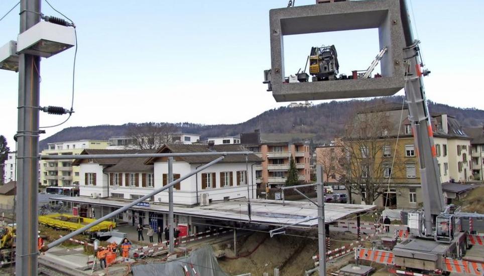 Das erste, 26 Tonnen schwere Betonelement der neuen Steiner Bahnhofsunterführung schwebt samt Arbeitsgerät in Richtung Baugrube. Bild: Ernst Hunkeler