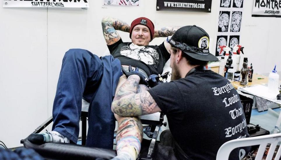 Messebesucher Bartol Simic lässt sich vom Westschweizer Tattoo-Artisten Simon Baron spontan einen Unterwelt-Gott aufs Bein zaubern. Bild: Evelyn Kutschera