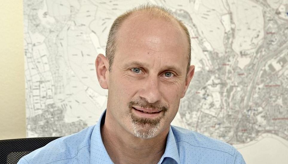 Beat Knecht sitzt in seinem Büro vor der Stadtkarte, auf welcher die städtischen Schulen und Kindergärten abgebildet sind. Bild: Tito Valchera