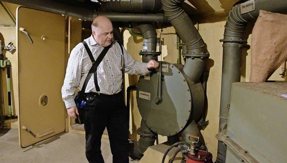 Thomas Burkhardt zeigt, wie die Lüftungsanlage im Bunker funktionierte. Die geöffnete Tür im Hintergrund führt zum Notausgang.