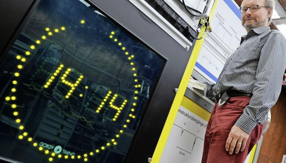 Andreas Bauch, Leiter der Arbeitsgruppe Zeitübertragung, steht im Zeitlabor der Physikalisch-Technischen Bundesanstalt in Braunschweig neben einer Atomuhr. Bild: Key