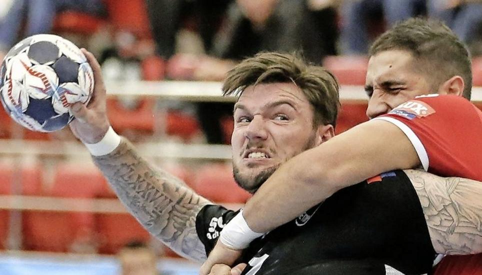 Harte Bandagen im Hinspiel in Bukarest (29:28): Johan Koch wird gebremst. Bild: Key