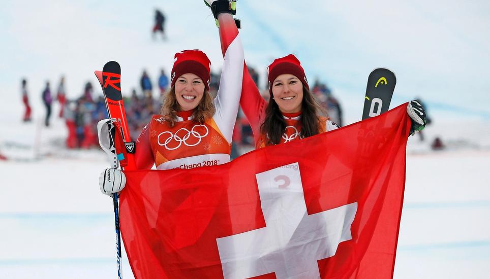 Schweizer Olympiapower und Siegesfreuden: Michelle Gisin (l.) und Wendy Holdener schwenken nach ihren Medaillenfahrten in der Kombination mit grossem Stolz die Schweizer Flagge. Bild: Key