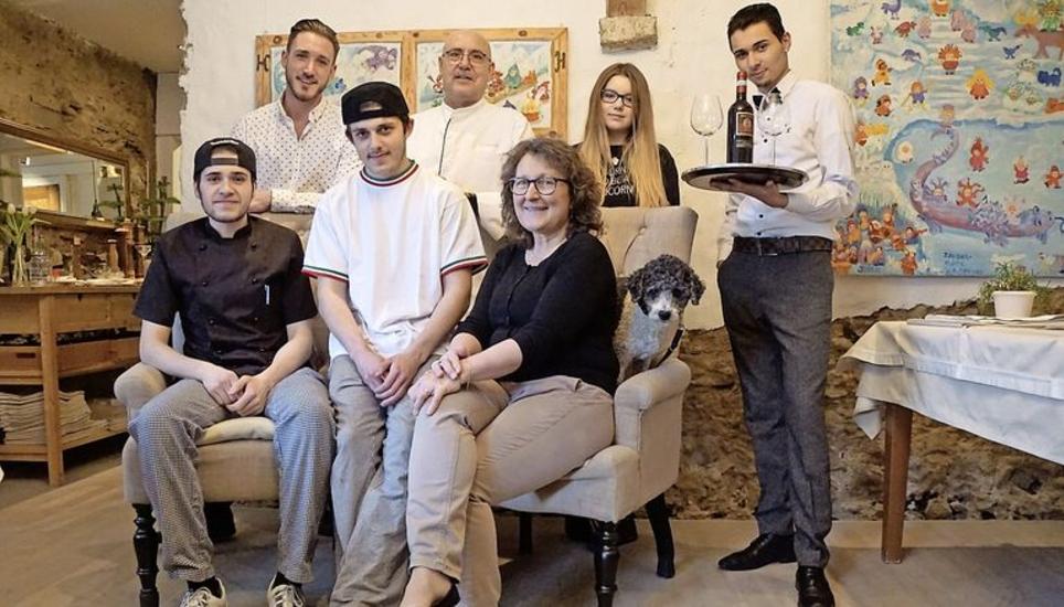 Lotti (auf dem Sofa rechts) und Potito Miscia (hinten, 2. v. l.) führen das Bistro Pizza Cantina mit Lehrlingen, die ihren Namen nicht in der Zeitung lesen möchten und die hier eine zweite Berufschance erhalten. Bild: Karin Lüthi