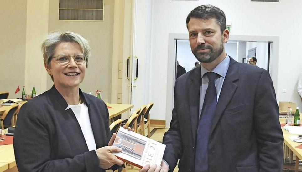 Sieger Gottfried Locher überreicht der unterlegenen Rita Famos zum Trost Martin Mosebachs Buch «Die 21: Eine Reise ins Land der koptischen Martyrer». Bild: Bruno Bührer