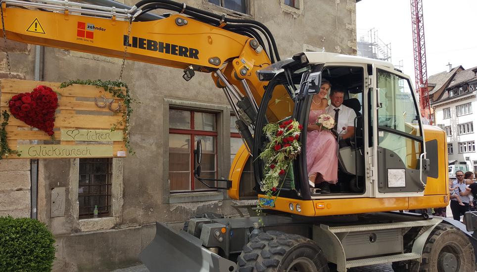 Lukas und Jeannette Nyffenegger sitzen für ein Foto in den Bagger der «pmb bau ag».
