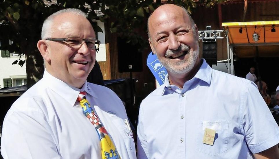 Bruno Kräuchi, Hettlinger OK-Präsident (l.), und Peter Brandenberger, Flaacher OK-Präsident, geben sich die Hand. Die Dahlienknollen sollen bald folgen. Bild: M. Gasser