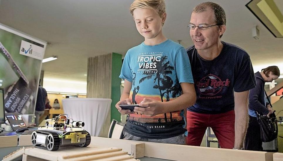 Linus Schnüriger und Vater Daniel versuchen, ein Raupenfahrzeug via Smartphone über eine Rampe zu steuern.