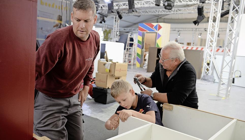 Beim Einrichten werden grosse und kleine Hände gebraucht. Michael Regli, Geschäftsleiter von Regli Weine, mit Sohn und Schwiegervater. Bild Selwyn Hoffmann