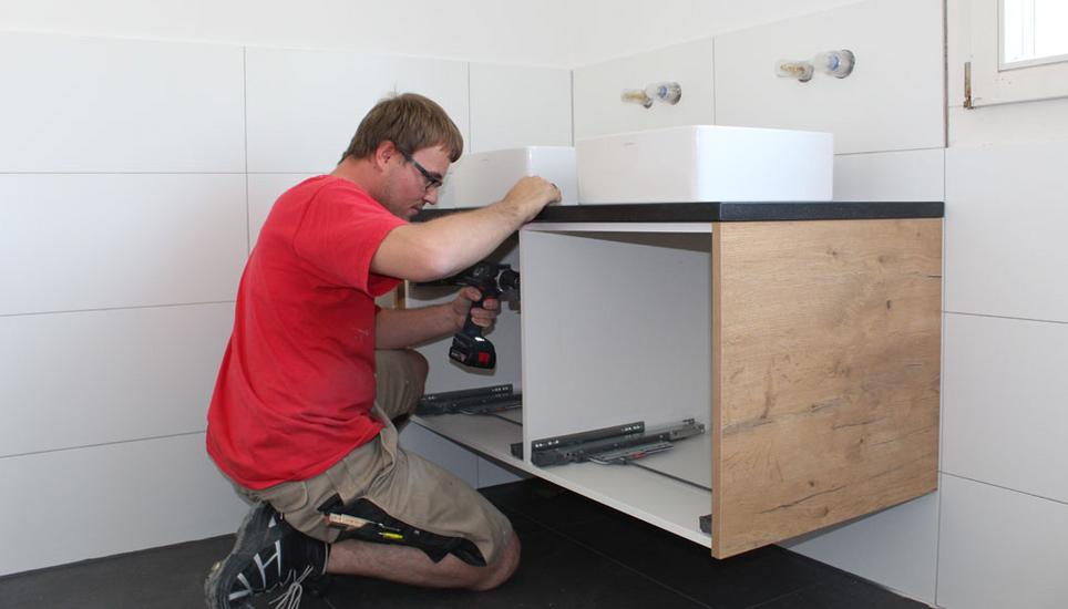 Individualität bis ins Bad: Ein Schreiner von Bollinger montiert das auf Mass gefertigte Badezimmermöbel in der Wohnung eines Kunden. Bollinger betreibt Standorte in Schaffhausen und in Schleitheim. Bilder: Bollinger GmbH