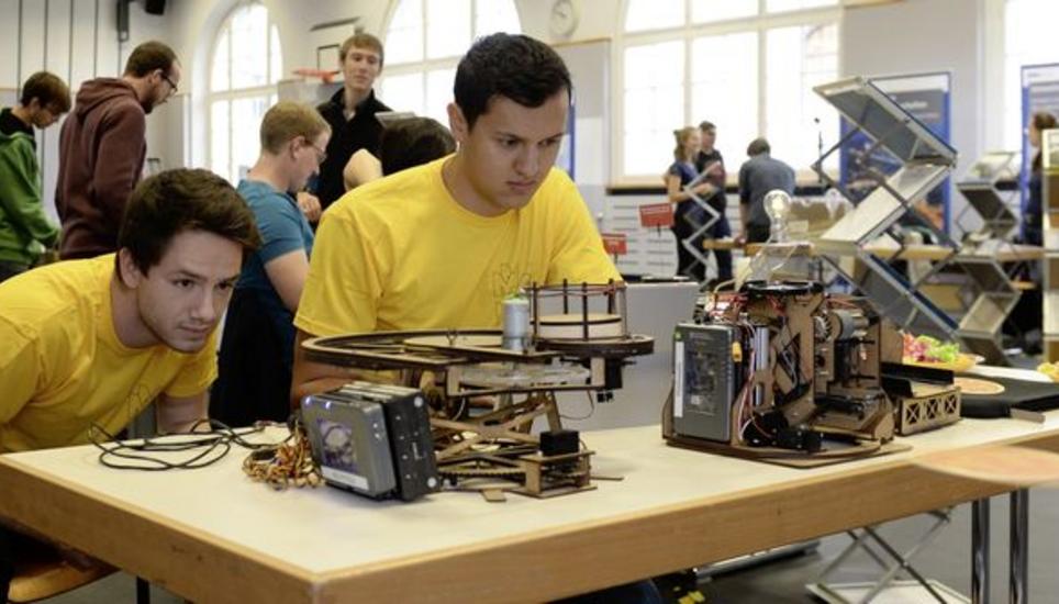 Marco Hauswirth und Fabien de Gasparo (rechts) mit ihrem Innovationsprojekt: Die Studenten lockten die Kantischüler an den Maschinenbaustand, indem sie ihre selbst entwickelte Pizzawurfmaschine vorführten. Bild: Selwyn Hoffmann