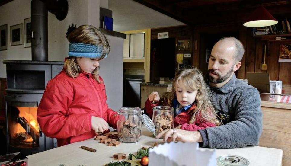 Die Weihnachtsengelchen Alina (l.) und Ladina dekorieren mit ihrem Vater Jon Hostettler die Tische in der Hasenbuck-Hütte weihnachtlich. Bild: Selwyn Hoffmann