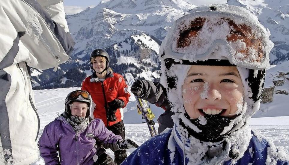 Ein Knabe amüsiert sich nach einem unfreiwilligen Schneebad – auch das gehört zu einem Skilager dazu. Bild: Key
