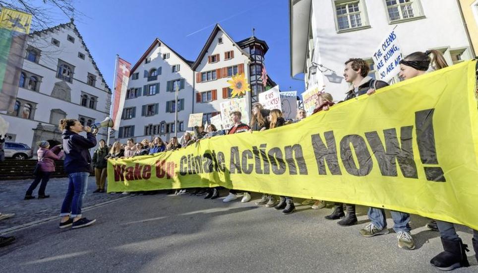 Millns (links) wurde nicht müde, die Masse zum Mitrufen zu motivieren. Vor dem Regierungsgebäude blieben die Schülerinnen und Schüler einen Moment länger stehen, um zu demonstrieren. Bild: Michael Kessler