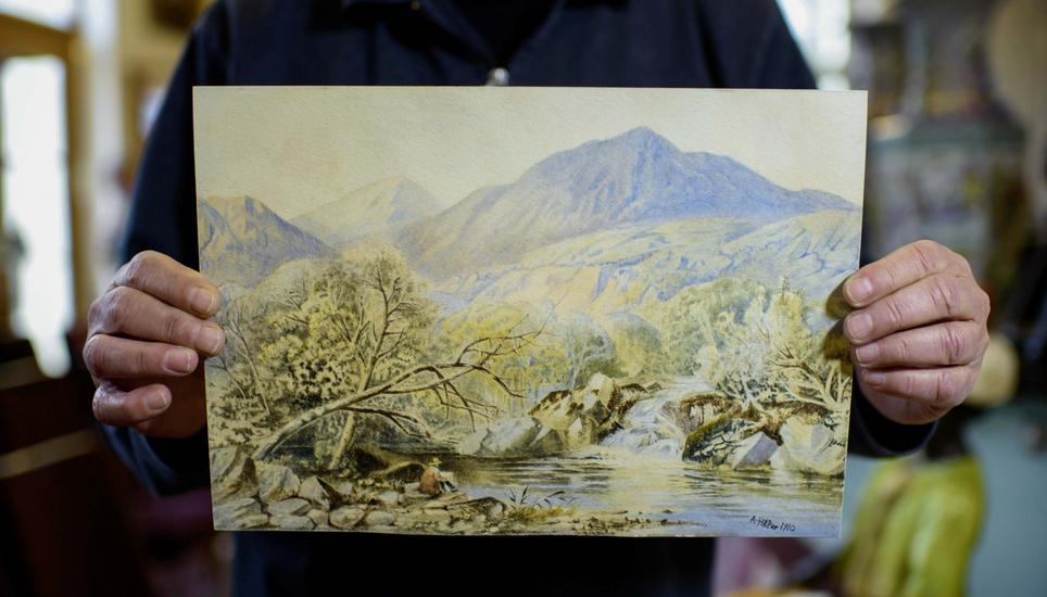 Ein Auktionator hält ein mutmassliches Aquarell von Adolf Hitler in die Kamera. Bild: Key