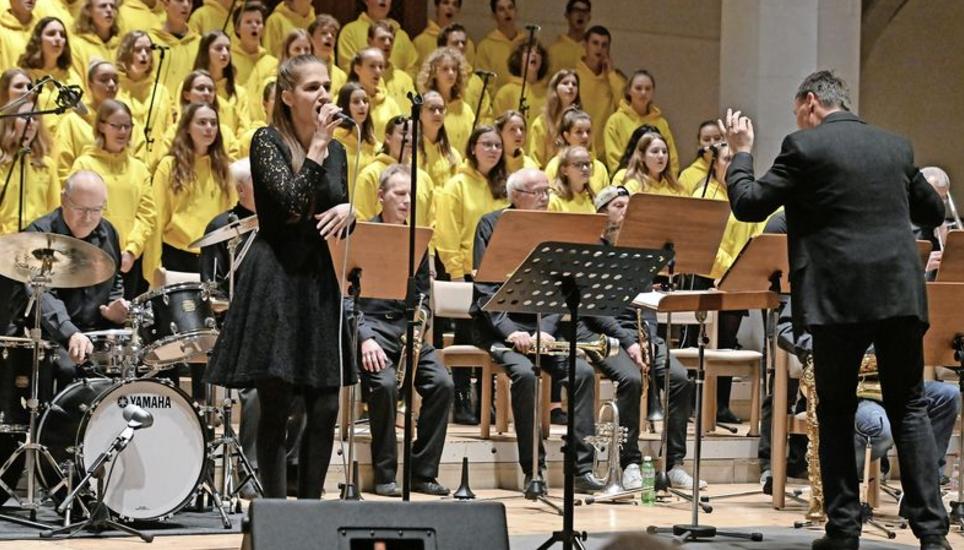 Von fein bis soulig: Sängerin Cindy Manser zeigte sich erstaunlich wandelbar. Im Hintergrund die Schaffhauser Big Band tonuM und der Kammerchor der Kantonsschule Schaffhausen in den neuen leuchtend gelben Chorpullis. Bild: Selwyn Hoffmann