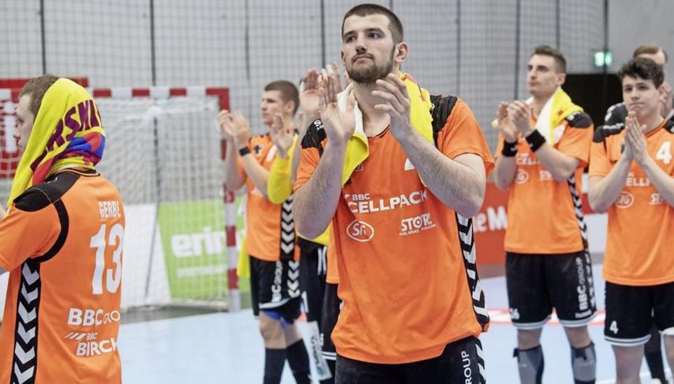 Die Kadetten Schaffhausen bedanken sich bei den mitgereisten Fans, den «Chübel» können sie ihnen aber nicht präsentieren, der geht abermals nach Thun. Bild: Key