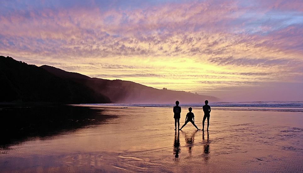 Die Geschwister geniessen den Sonnenuntergang in Neuseeland am Strand. Bild: Claus Platten