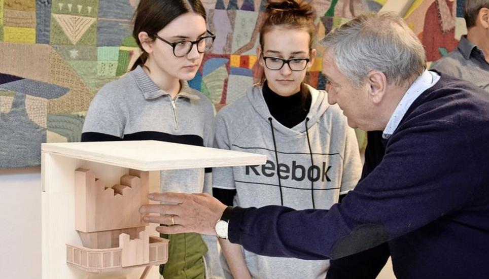 Architekt Bruno Bossart zeigt an einem Modell, wie der Windfang im Münster zukünftig aussehen wird. Bild: Melina Ehrat