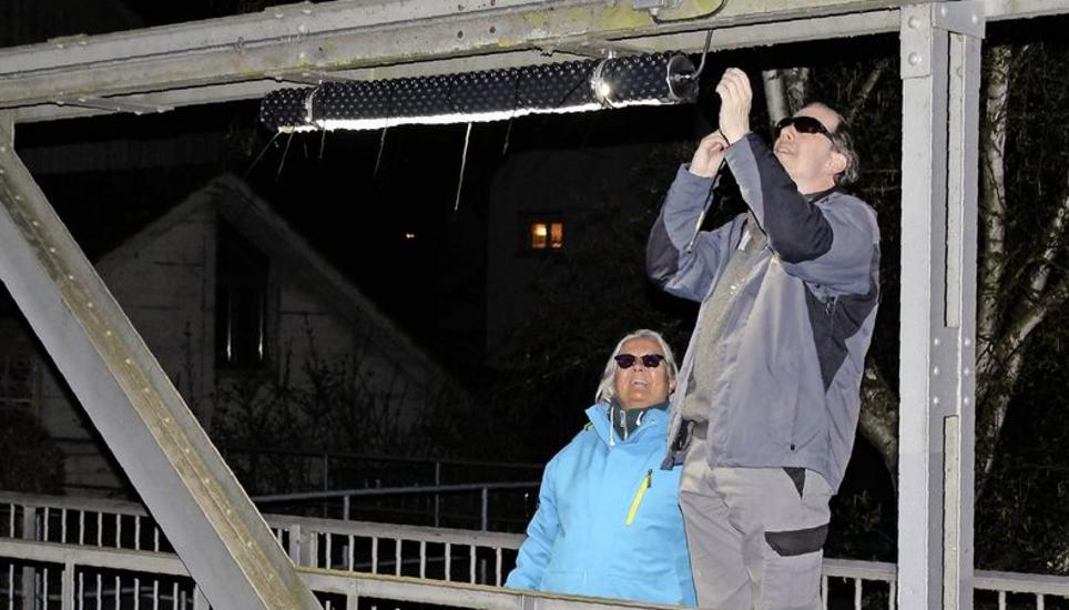 Mit Sonnenbrillen gegen das grelle Licht: Mit Kabelbindern werden die Noppenfolien befestigt. Bild: Stefan Salzmann