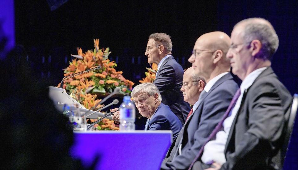 Yves Serra (stehend) hielt seine letzte Rede als Konzernchef. Er ist aber neu im Verwaltungsrat und ersetzt Gerold Bührer (sitzend, Erster von links). Neuer Konzernchef ist Andreas Müller (Zweiter von rechts). Bild: Michael Kessler