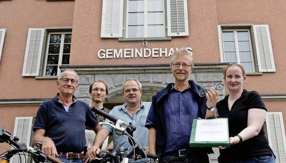 Franz Rohner, Martin Schwarz, Daniel Meister und Daniel Berti (von links) überreichten Gemeindeschreiberin Janine Rutz Unterschriften und ein Mini-Tandem. Bild: Melina Ehrat