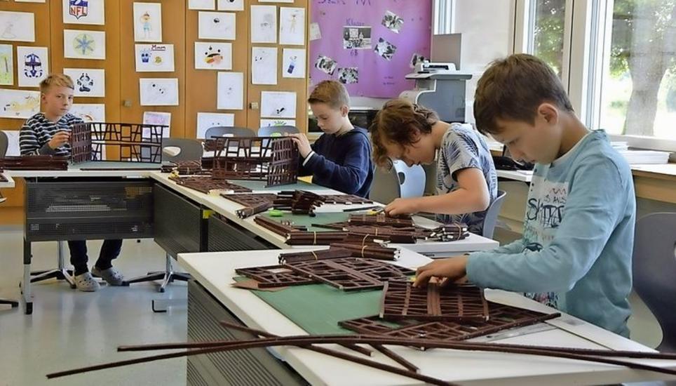 Vier Stammheimer Schüler konzentriert bei der Konstruktion von Riegelhäusern. Bild: Sonja Werni