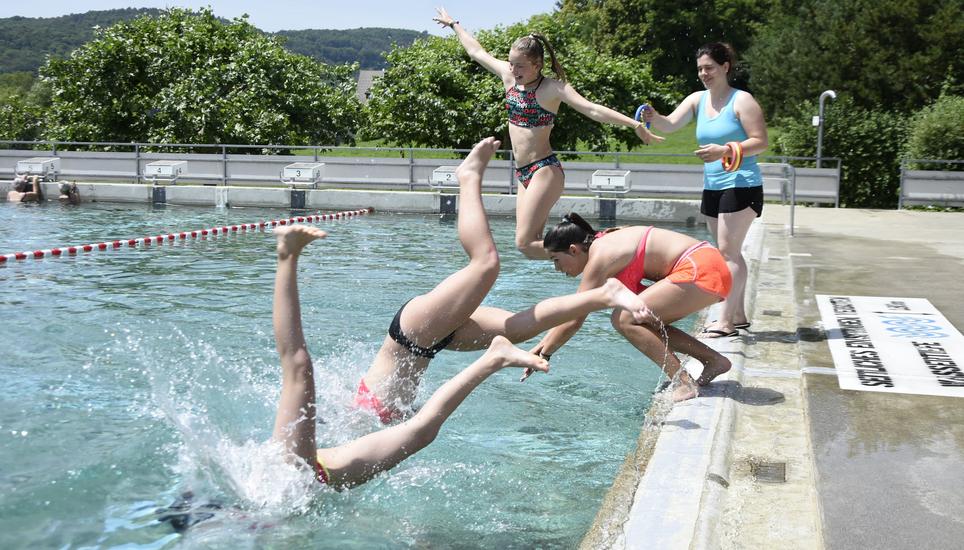 Tauchringe statt Turnringe: Lehrerin Mirjam Schär (im blauen T-Shirt) hat mit ihrer sechsten Klasse die Turnhalle gegen das kühle Nass in der Thaynger Badi Büte eingetauscht. Während der Sportlektion übt sie mit vier Schülerinnen das Tauchen. Bild: Melina Ehrat