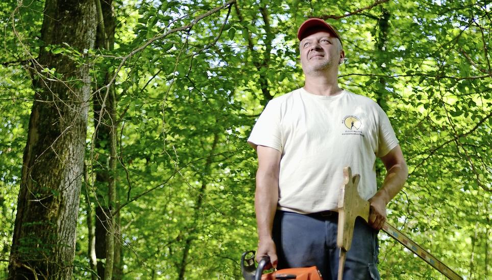 Förster Michael Ryser mit einer Motorsäge und einer Kluppe, einem Instrument zur Vermessung von Baumstämmen. Bild: Zeno Geisseler