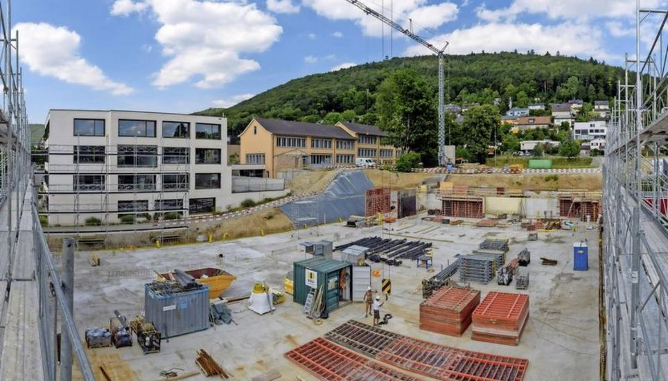 Der Zimmerberg-Schulkomplex in Beringen wird erweitert durch den Neubau einer Dreifachsporthalle, die im Jahr 2020 fertig sein soll. Die dunkelgelben Bauwerke im Hintergrund beherbergen die sanierten Schulräume sowie die Schulraumerweiterungen. Bild: Michael Kessler