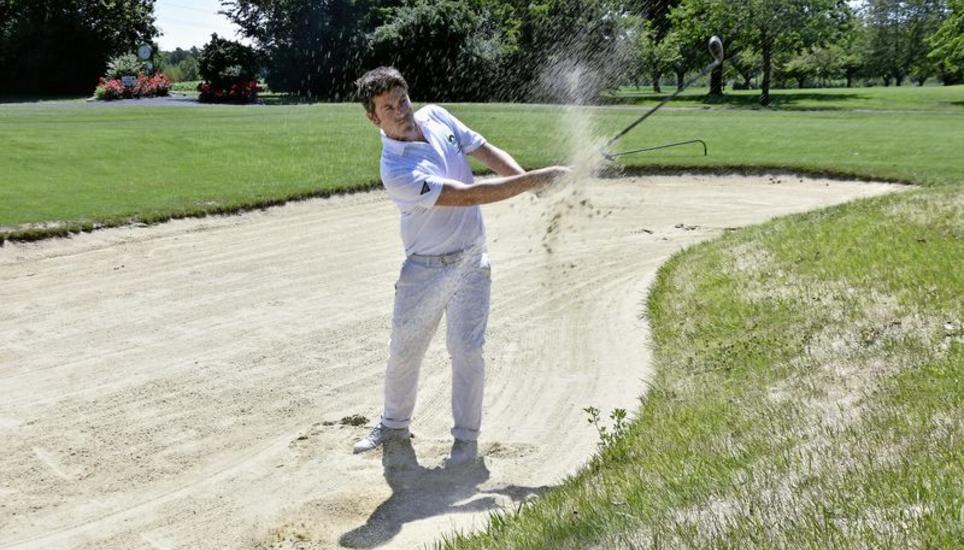 Sascha Georgi leitet als Head Pro die Golfschule im Golfclub Rheinblick in Nack. Aus dem sogenannten Bunker schlägt er den Golfball ins Grüne. Bilder: Tamara Schori