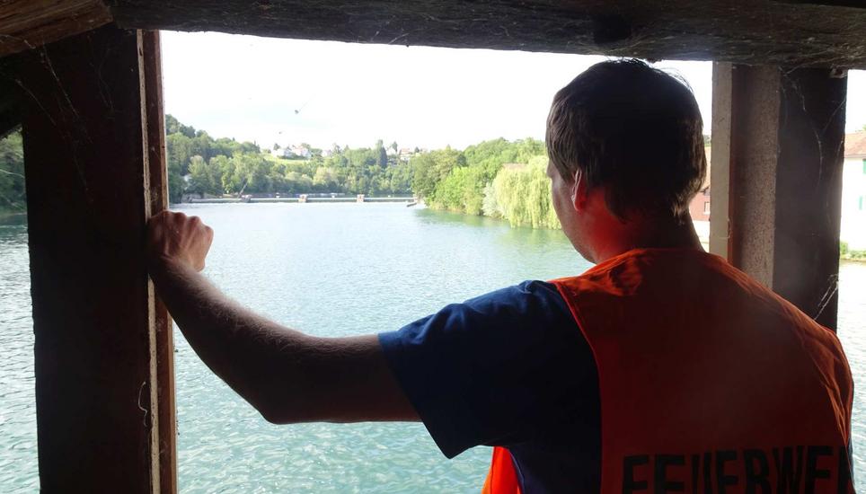 Ein Feuerwehrmann sucht den Rhein ab.