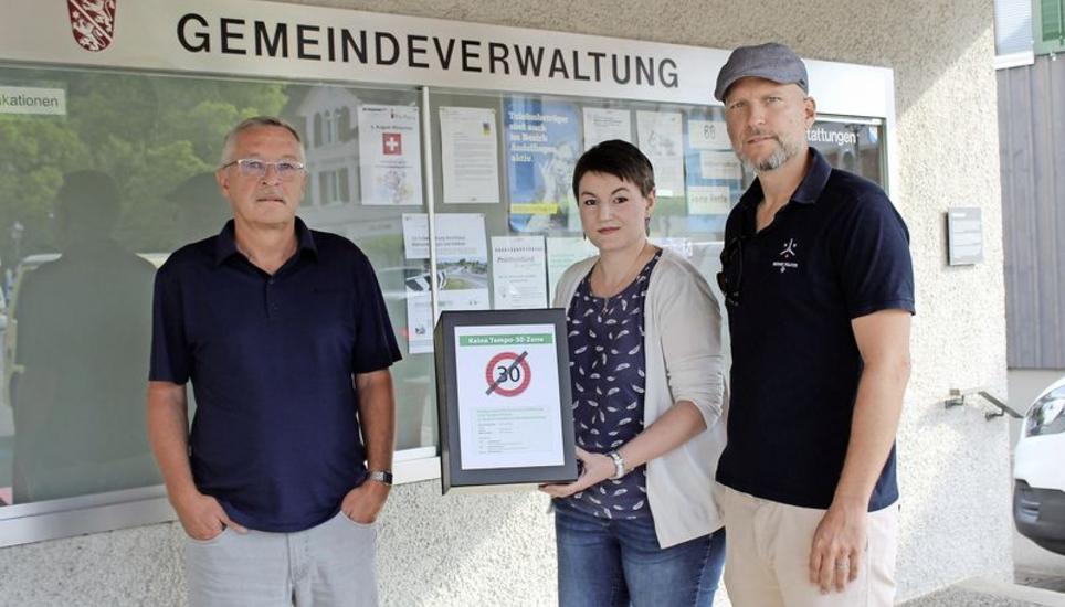 Gemeindepräsident Hansruedi Jucker (links) kriegt das Paket mit der Umfrage zur Tempo-30-Zone von der SVP Andelfingen (Irina Pletscher, Mike Hotz) überreicht. Bild: ssa