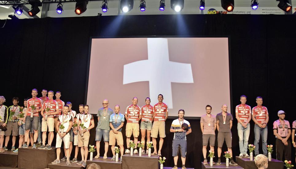 Lauschen den Schweizer Psalm: Das Podium der Ultracycling-Schweizer-Meisterschaft mit den in die roten Trikots eingekleideten Siegern. Bild: Philipp Hagen