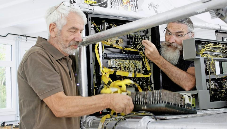 Peter Wägli (links) und Fritz Franz Vogel öffnen die Rückseite eines IBM-Computers. Beide geben während der Ausstellung Auskunft über die Exponate. Bild: Dieter Ritter