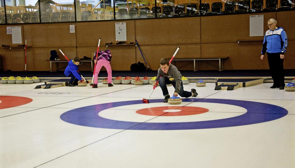 Kursleiter Meinrad Bamert zeigt den Kindern, worauf es beim Curling ankommt. Bild: fni
