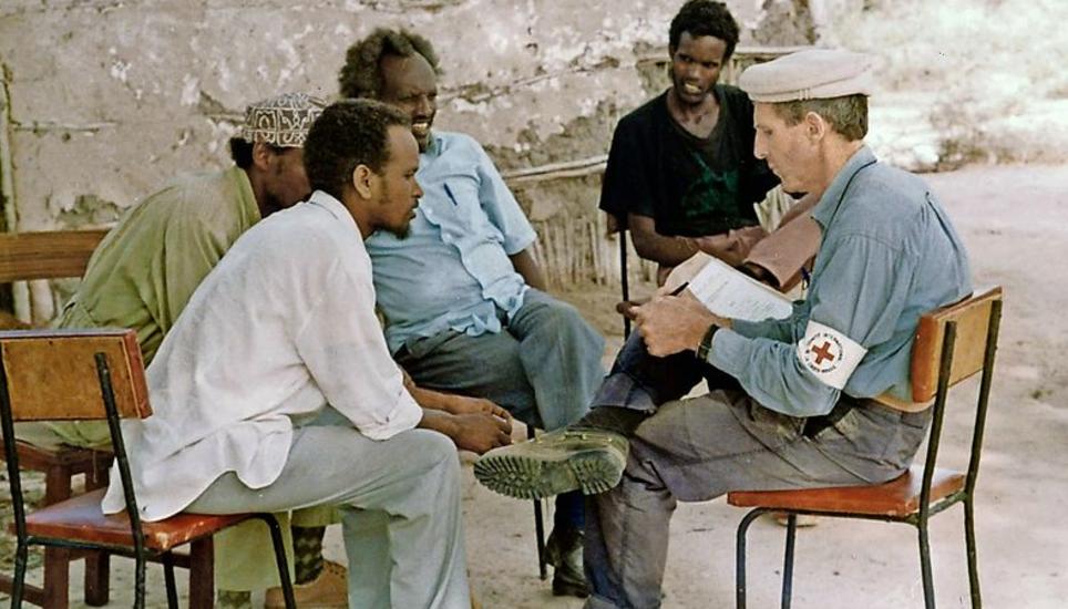 Andreas Schiess mit IKRK-Armbinde im Jahr 1992 im Gespräch mit Mitgliedern eines lokalen Komitees für die Verteilung von Lebensmitteln in Hossingo in Somalia. Bild: zvg