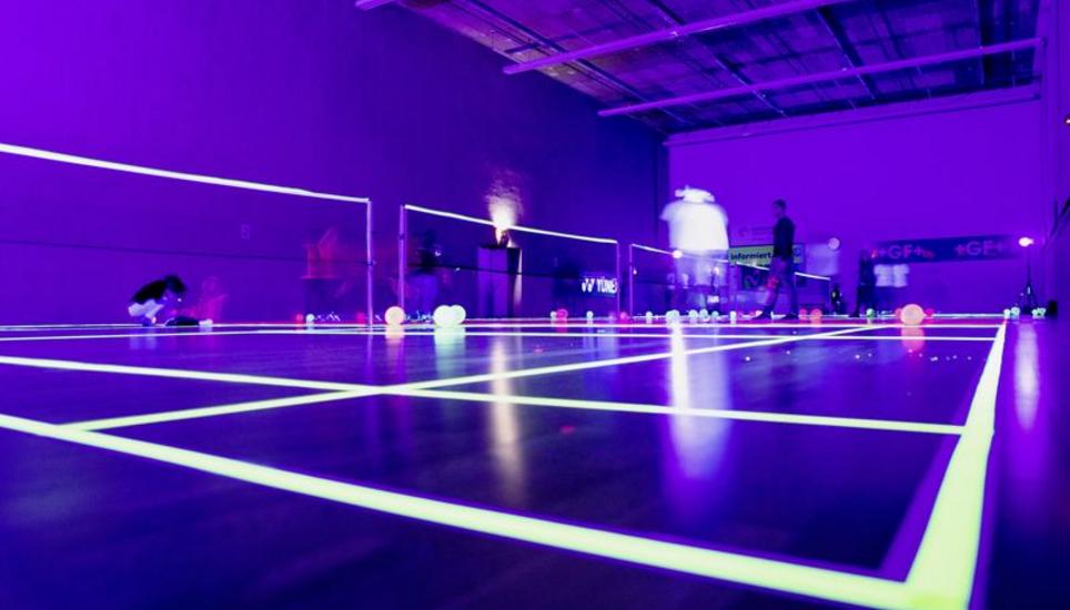 Die Badminton-Halle des Aranea-Kletterzentrums wurde für das Jahresfest in Schwarzlicht getaucht. Die Fluoreszenzfarbe der Seitenlinien leuchtet .