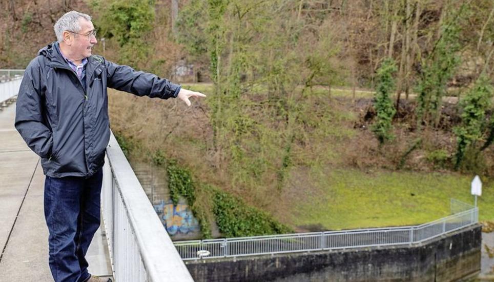 Walter Vogelsanger, Leiter der Begleitgruppe zur Fischdurchlässigkeit am Kraftwerk Schaffhausen, zeigt, wo ein «Umgehungsbach» erstellt werden könnte. Ganz unten rechts im Bild: Der Eingang zur bestehenden Fischtreppe. BIld: Roberta Fele