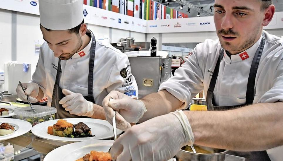 Die Schweizer Armeeköche Benjamin Anderegg und David Lanz beim Anrichten. Bild: chm