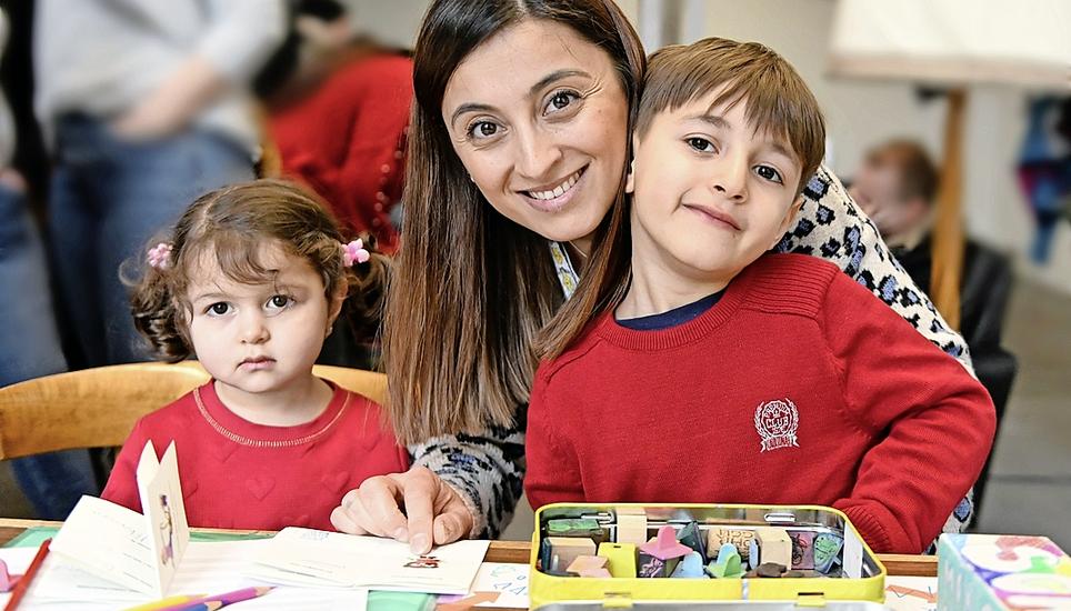 In der Spielecke zeigt die Türkin Serpil Selvi ihren Kindern Senan (r.) und Sinem, wie man ihre Namen schreibt.
